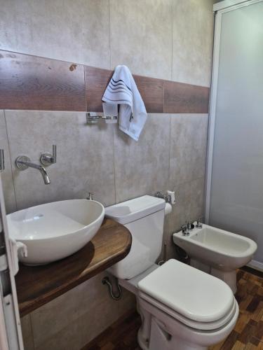 a bathroom with a white toilet and a sink at Los sauces in Gualeguaychú