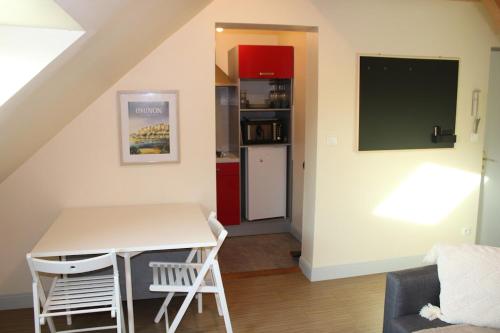 Una cocina con una mesa y sillas en una habitación. en Le Saint Georges, en Chinon