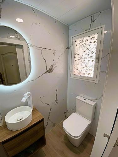 a bathroom with a toilet and a sink and a mirror at ThE WHALE HOUSE in El Campello
