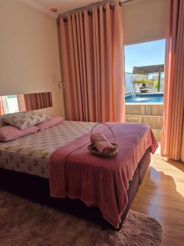 a bedroom with a bed with a purse on it at Casa Boituva in Boituva
