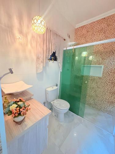 a bathroom with a toilet and a glass shower at Casa Boituva in Boituva