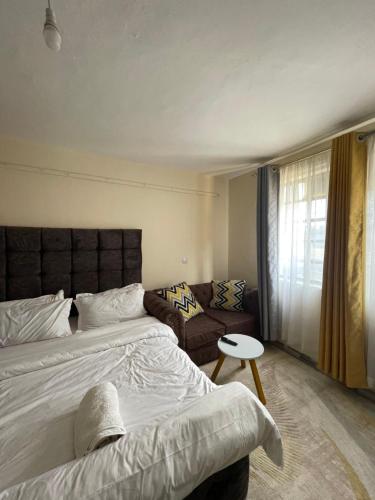 a bedroom with a bed and a couch at Studio Bnb in Kitengela 