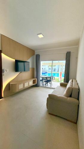 a large living room with a couch and a television at Condomínio Boas Vistas - 31 A in Aracati