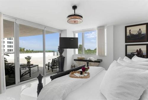 a bedroom with a white bed and a balcony at Southeast Oceanfront Residence in Hollywood Beach