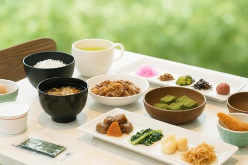 京都市にある変なホテルプレミア京都 五条烏丸（旧ウォーターマークホテル京都）の食べ物の皿とコーヒーカップが置かれたテーブル