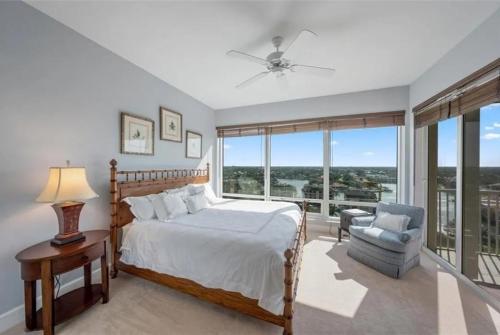 a bedroom with a bed and a chair and windows at Spacious Gulf-view Residence in Naples