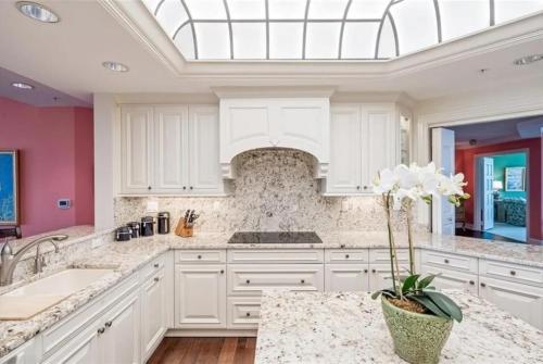 a kitchen with white cabinets and a skylight at Spacious Gulf-view Residence in Naples