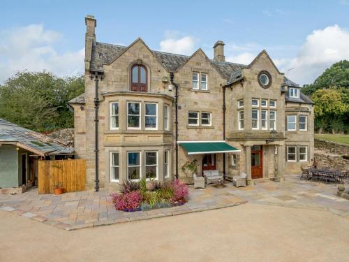 a large stone house with a patio in front of it at The Marle in Belper