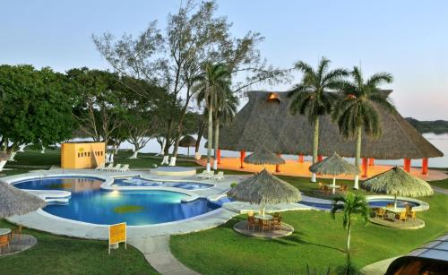 a resort with a swimming pool with chairs and umbrellas at Hotel Terranova in Coatzacoalcos