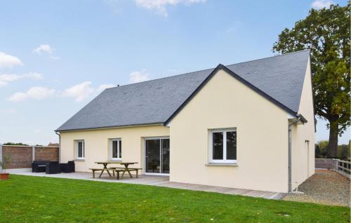 a white house with a picnic table on a lawn at Awesome Home In Bacilly With Wifi in Bacilly