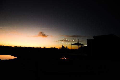 a silhouette of a sunset with an umbrella at Casa de Ferro 287 Aconchego e Praticidade in Venâncio Aires