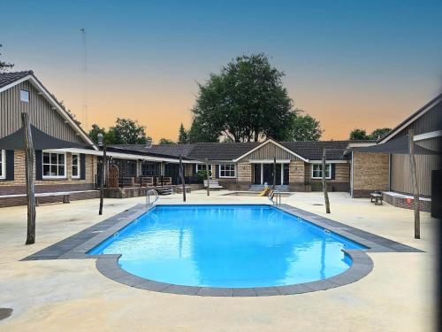 a large swimming pool in front of a building at Chalet Kieftveen with hot tub for four Person in Voorthuizen