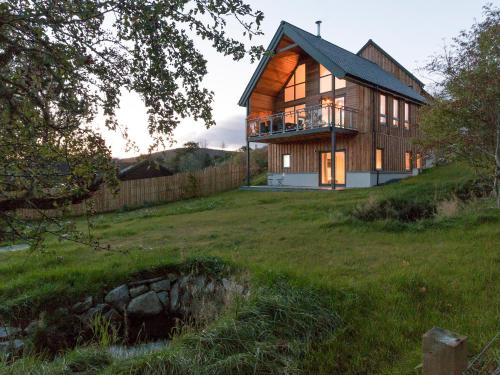 a house on top of a grassy field at Strathspey Lodge in Duthil