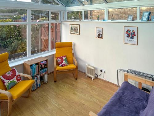 a living room with a couch and a chair at Primrose Cottage in Little Rissington
