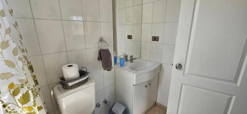a white bathroom with a toilet and a sink at Habitacion Matrimonial privada en machali con parcking y wifi in Rancagua