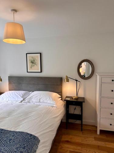 a bedroom with a bed and a table with a mirror at The Cottage in Bristol