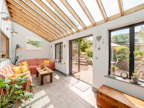 Salón acristalado con sofá y mesa en Crossroads, en Braunton