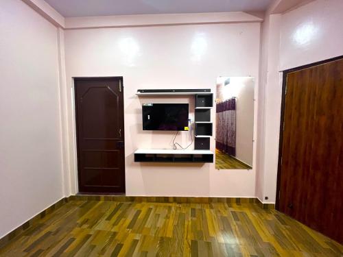 a room with a tv on a wall at Trilok Residency - Dashashwamedh Ghat - Varanasi in Varanasi