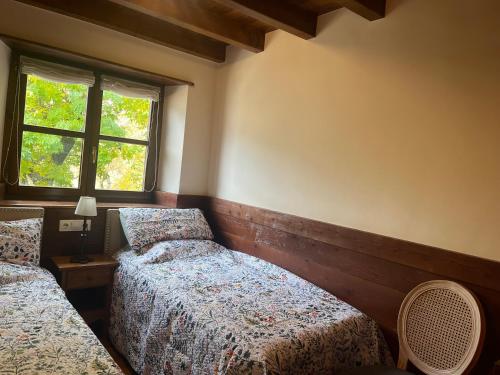 a bedroom with two beds and a window at GESSA, VAL d'ARAN in Gessa