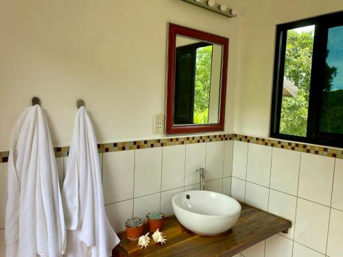 une salle de bain avec un lavabo blanc et une fenêtre dans l'établissement Novelyn's Seaview Hideaway, à Larena