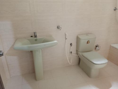 a white bathroom with a sink and a toilet at Golden Heavens kengalla in Kandy