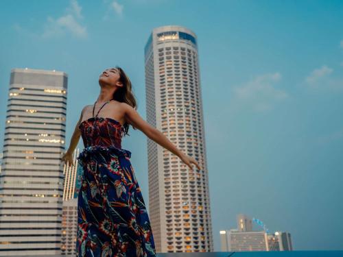 a woman in a dress standing in front of a city at Swissotel The Stamford Singapore in Singapore