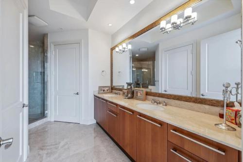 a bathroom with a sink and a large mirror at Penthouse In The Sky With Water Views in Naples