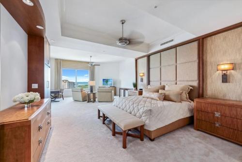 a bedroom with a large bed and a living room at Penthouse In The Sky With Water Views in Naples
