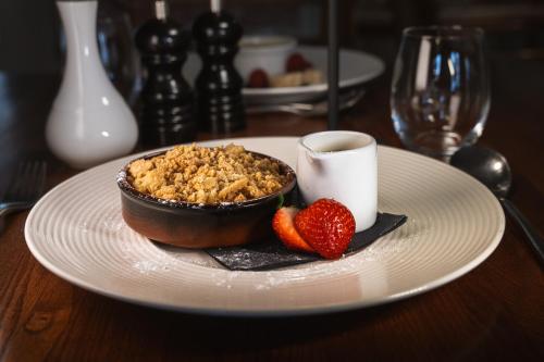 a plate of food with strawberries and a cup of coffee at The Royal Hotel in Comrie