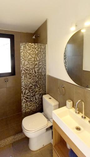 a bathroom with a toilet and a sink and a mirror at Cubos habitables 3 in San Antonio de Arredondo