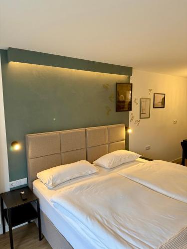 a bedroom with a large white bed with a green wall at Zentrales Studio-Appartment mit Terrasse in Hildesheim
