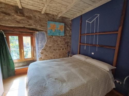 a bedroom with a bed and a blue wall at Habitación Doble Azul Baño Privado Cartes in Cartes