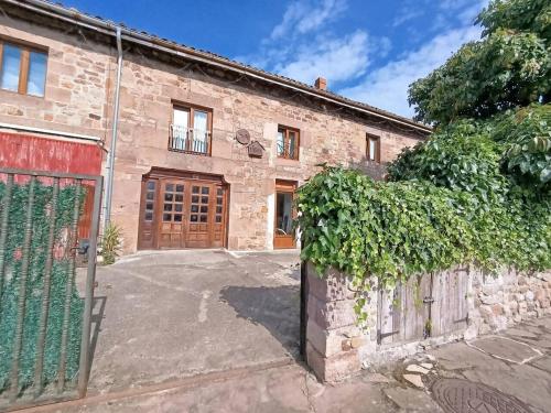 an old stone building with a gate and a fence at Habitación Doble Azul Baño Privado Cartes in Cartes