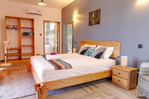 a bedroom with a large bed with white sheets at Villa Soleil de L'est in Port Mathurin