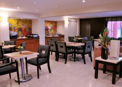 a restaurant with tables and chairs and a counter at Hotel Terranova in Coatzacoalcos