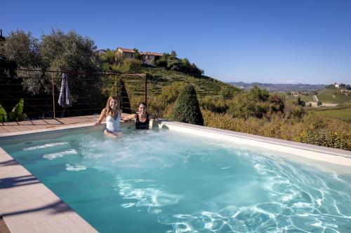 two girls are standing in a swimming pool at Hotel Casa Pavesi in Grinzane Cavour