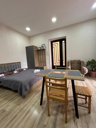 ボルジョミにあるN&G Apartmentのベッドルーム1室(ベッド1台、テーブル、ベッドサイドシックスシックス付)