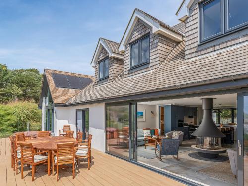 a house with a patio with a table and chairs at Blue Seas in Mawgan Porth