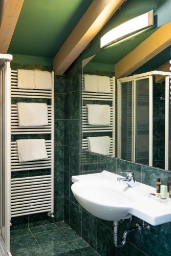 a bathroom with a sink and a mirror and towels at Villa Miravalle - Boutique Hotel in Riva del Garda