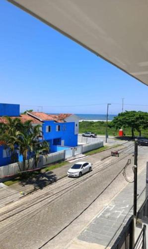 ポンタウ・ド・パラナにあるStudio 22 vista para o marの青い建物のある道路を走る白い車