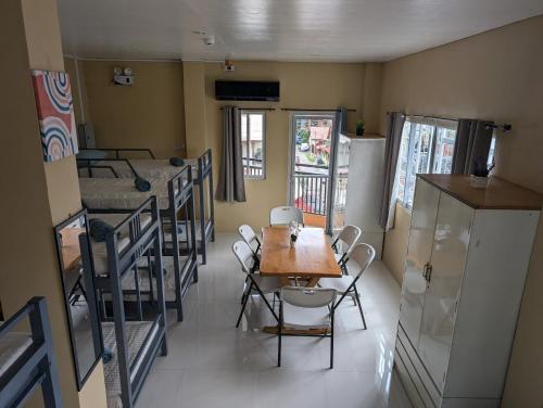 a room with several bunk beds and a table and chairs at L'islo INN in Davao City