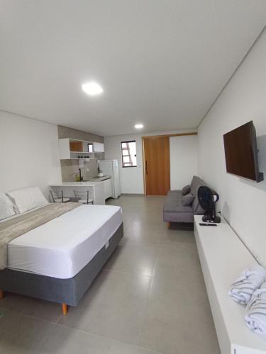 ポンタウ・ド・パラナにあるStudio 22 vista para o marの広いベッドルーム(ベッド1台、ソファ付)