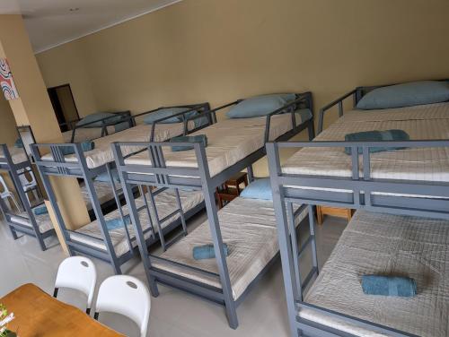 a group of bunk beds in a room with a table and chairs at L'islo INN in Davao City