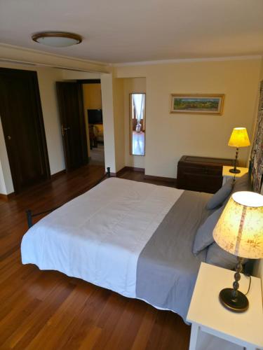 Un dormitorio con una gran cama blanca y dos lámparas. en Langhe Bee Home, en Cravanzana