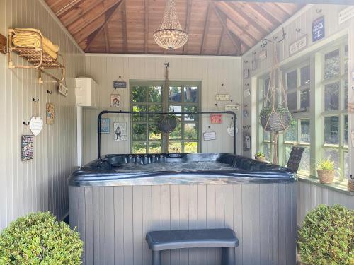 a jacuzzi tub in a house with a bench at Bluebell Cottage - 27635 in Darenth