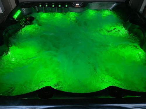 a green bath tub filled with green water at Bluebell Cottage - 27635 in Darenth