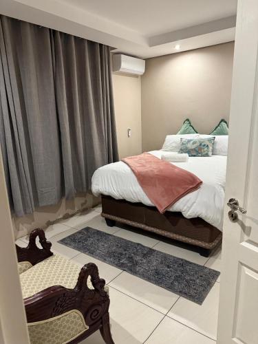a small bedroom with a bed and a window at Cozy Central BNB in Mbabane