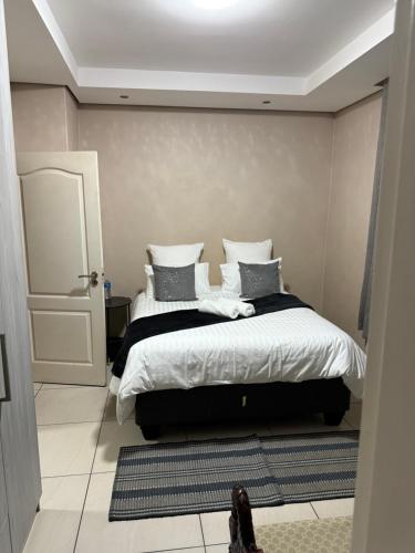 a bedroom with a bed with pillows on it at Cozy Central BNB in Mbabane