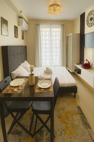 a bedroom with a bed and a table and chairs at Luxury poolview condo with pool access! in Suba