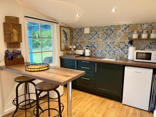 a kitchen with green cabinets and a wooden counter top at Oak View Lodge: Cosy, Countryside Retreat in Maybole